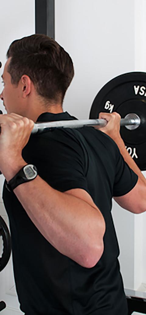 A student lifting weights behind his head
