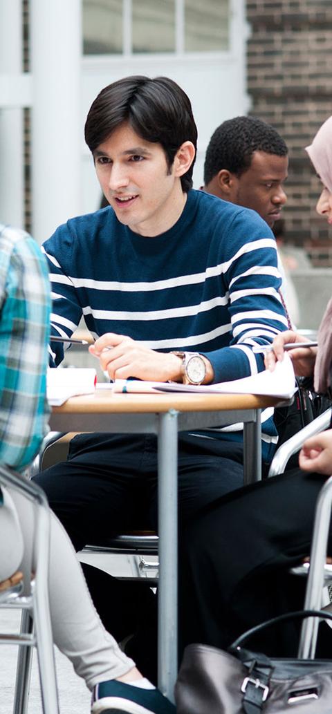 A group of middlesex students sit at tables in the quad