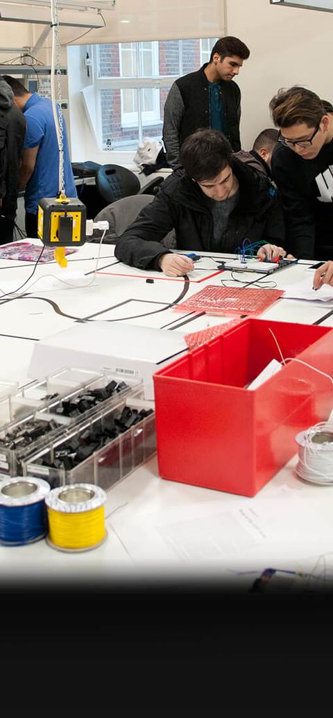 students work with circuit boards in busy laboratorys