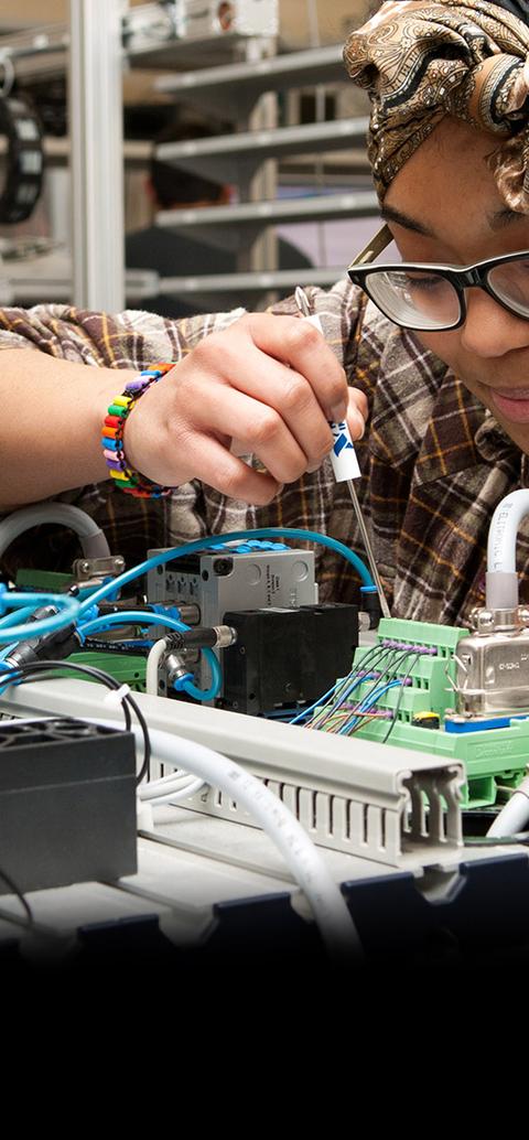 Female student working on engineering equipment in the 91��ɫ mechatronics lab