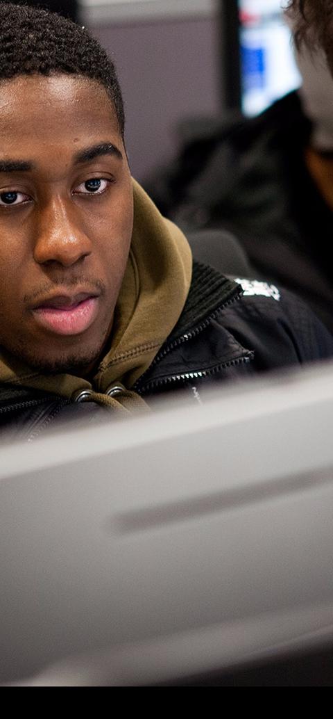 Group of students huddled over a computer