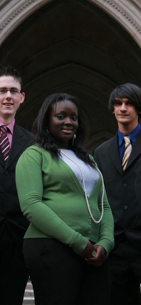 Students smiling in front of a building