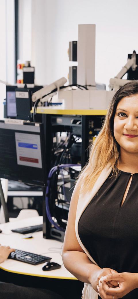 A student smiling in an IT lab