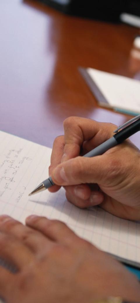 A student writing on a notepad