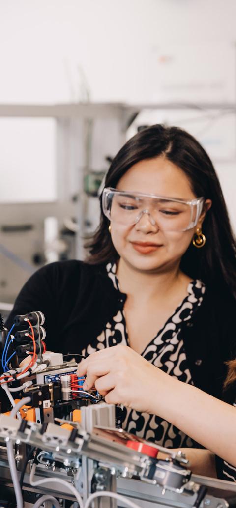 Two students working on a robot arm