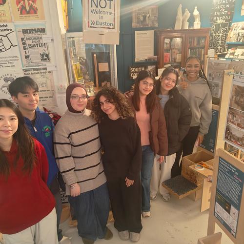 A group of young people at an exhibition looking towards the camera