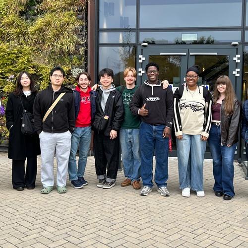 A group of people pose in front of a building