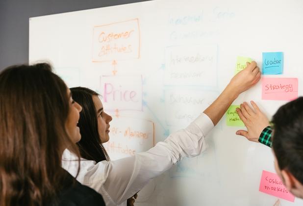 Students work together on a brainstorming activity using sticky notes in a business management class.