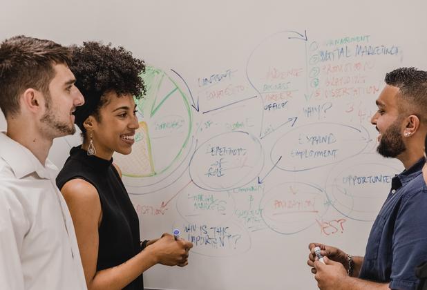 Business students work together on a group activity using a whiteboard.