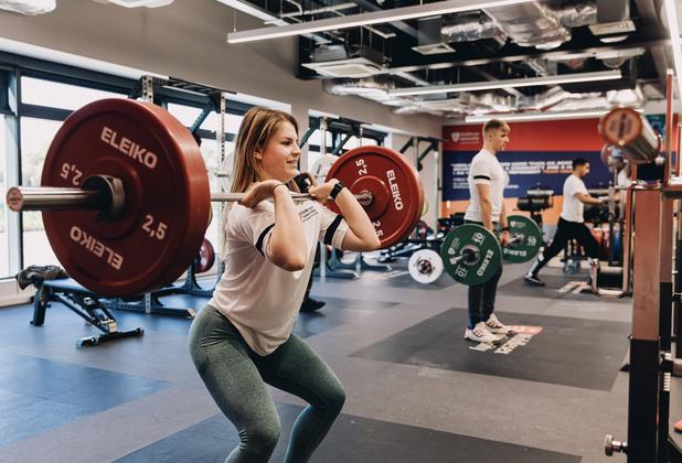 A student lifting weights at the gym in the West Stand