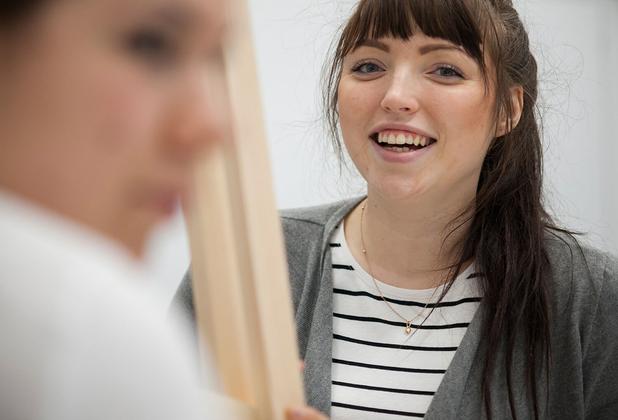 Smiling middlesex uni student holding a skirting board