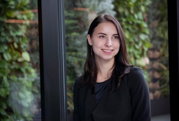 smartly dressed student, backdrop of large window looking out onto leafy background