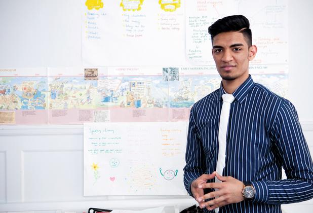 A teacher standing in front of a display of work