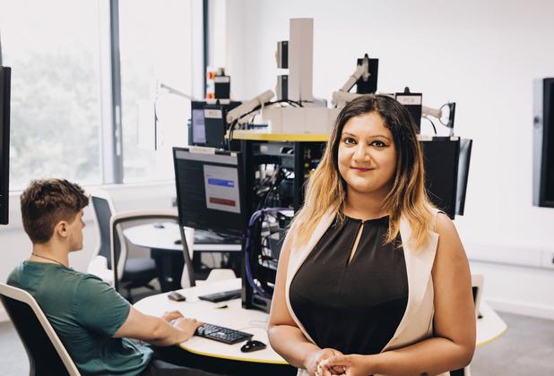 A student smiling in an IT lab