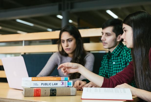 Students studying law with a laptop on the desk.