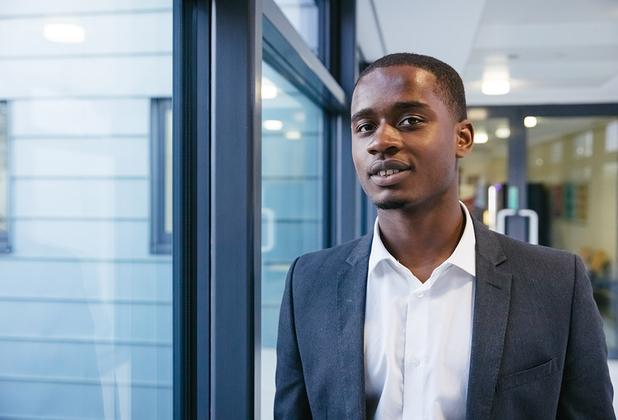 A headshot of a man dressed business casual standing in Grove Building