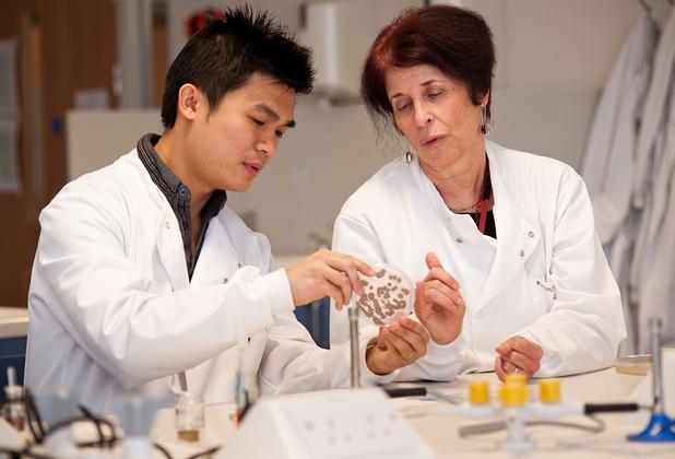 a student doctor examining something with a teacher