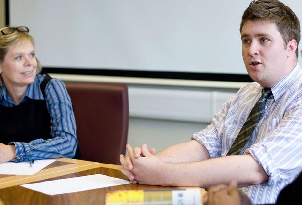 mature students in formal wear sat down in discussion
