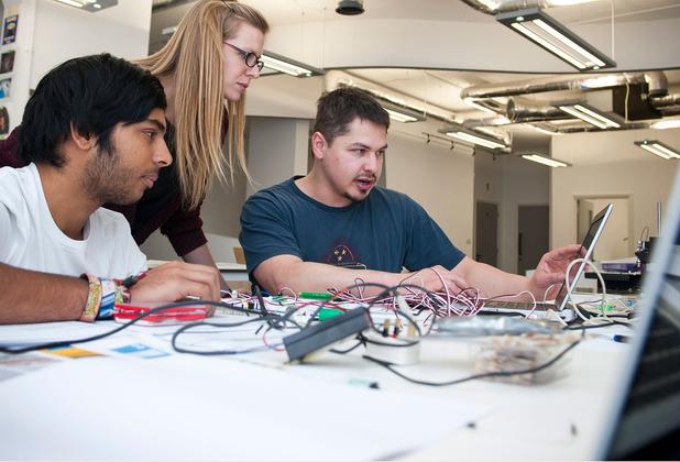 three students working on a computer