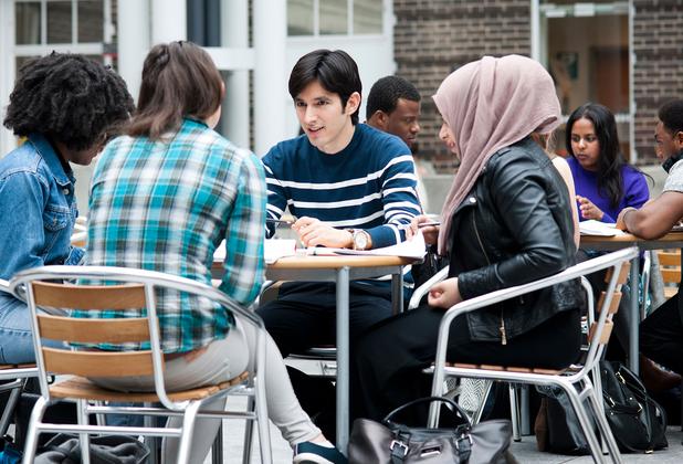 A group of middlesex students sit at tables in the quad