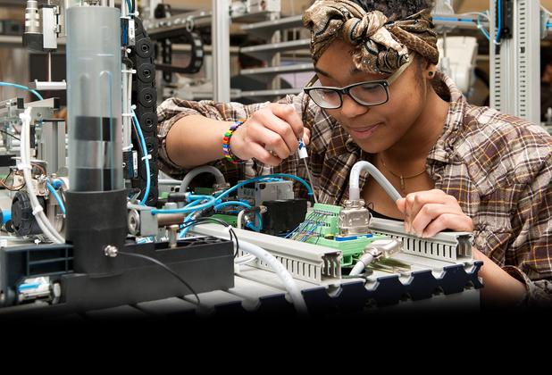 Female student working on engineering equipment in the MDX mechatronics lab