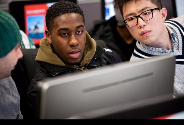Group of students huddled over a computer