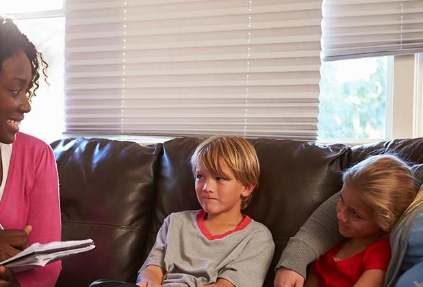 two ladies sat on a sofa with social worker