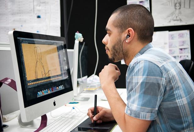 A student working on an animation project with an Apple Mac and stylus