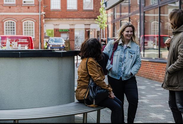 two girls walk along chatting outside middlesex university