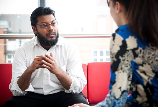 Male student social worker consults a female whose face is hidden