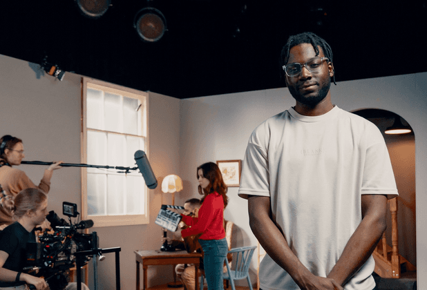 Một người đàn ông đứng trước xưởng sản xuất phim