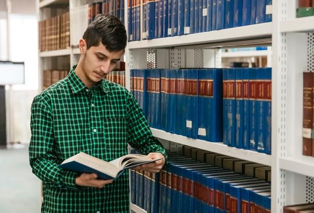 Male law student reading book in library