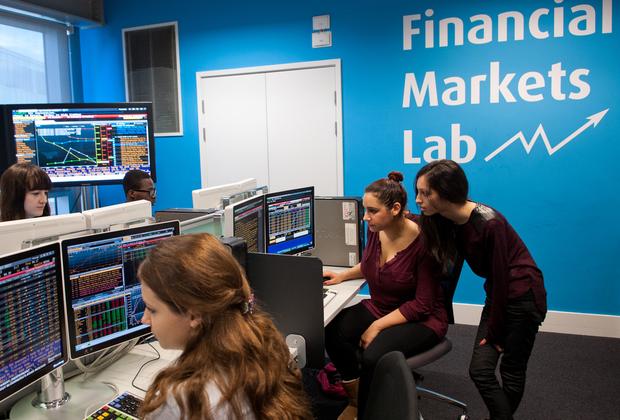 Students use professional market data terminals in a financial markets lab to analyse trading activity and collaborate on investment concepts