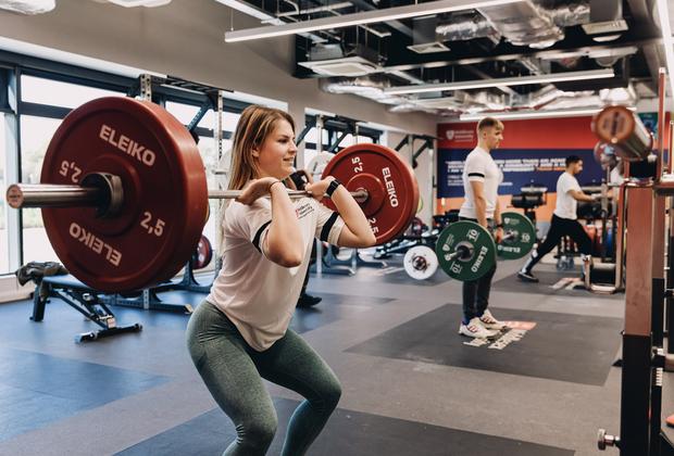 A student lifting weights at the gym in the West Stand