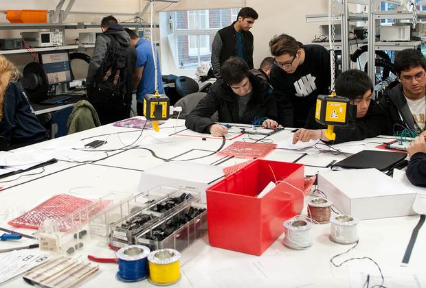 students work with circuit boards in busy laboratorys