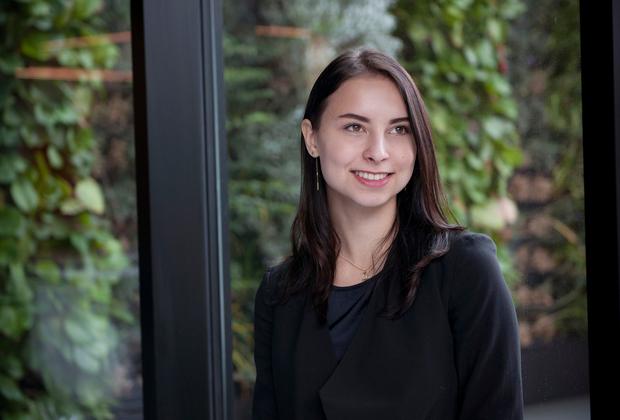 smartly dressed student, backdrop of large window looking out onto leafy background