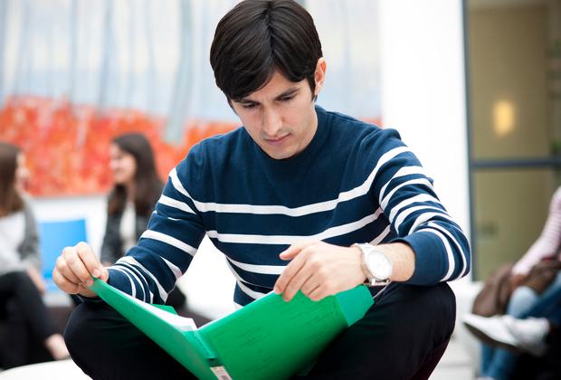 sitting student reading folder