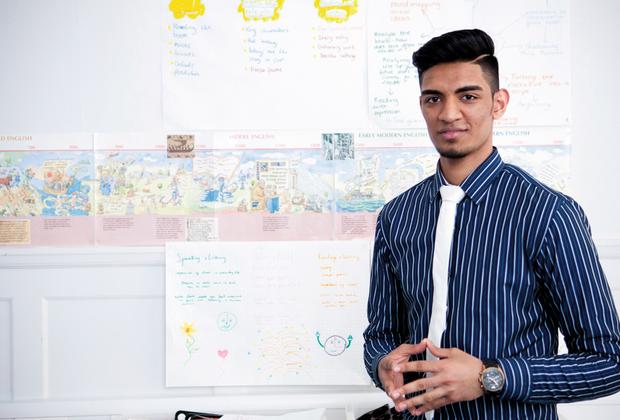 A teacher standing in front of a display of work