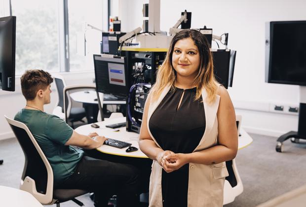 A student smiling in an IT lab