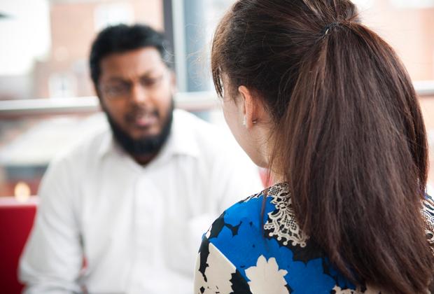 close up of back of patients head as they talk to therapist in background