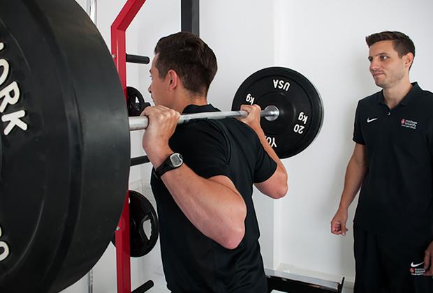 A student lifting weights behind his head