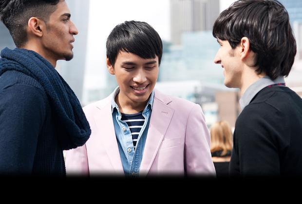 three students facing each other smiling