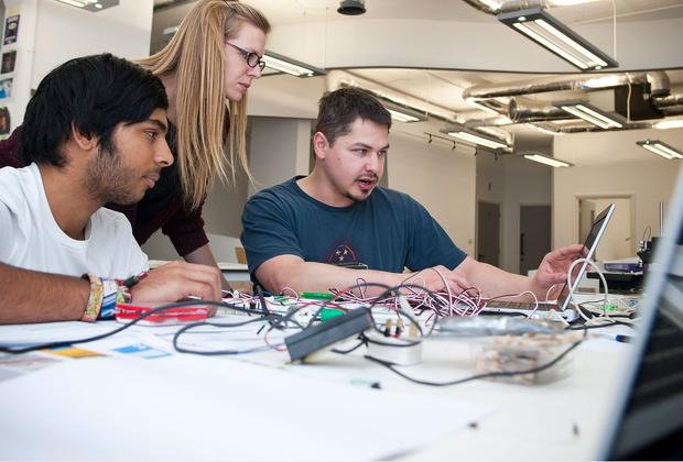 three students working on a computer
