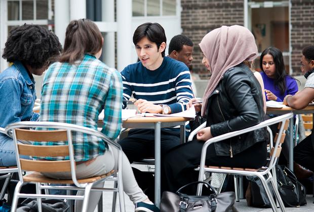 A group of middlesex students sit at tables in the quad