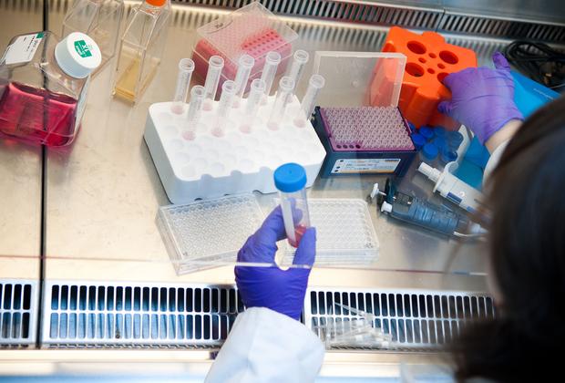Medical student in a lab mixing text tubes