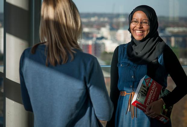 Two students chatting on campus on a sunny day