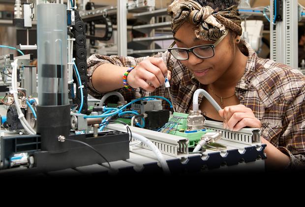 Female student working on engineering equipment in the MDX mechatronics lab