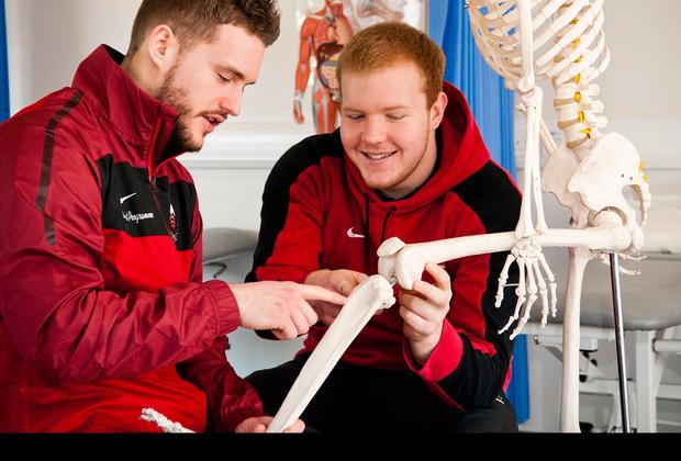 two students examining a skeleton