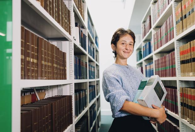 female middlesex university student in the sheppard library carrying books