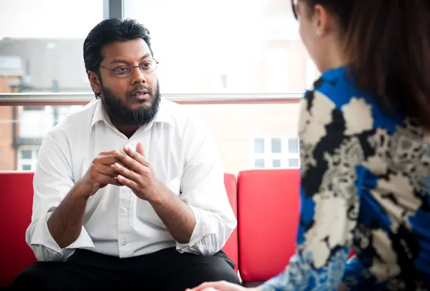 Male student social worker consults a female whose face is hidden